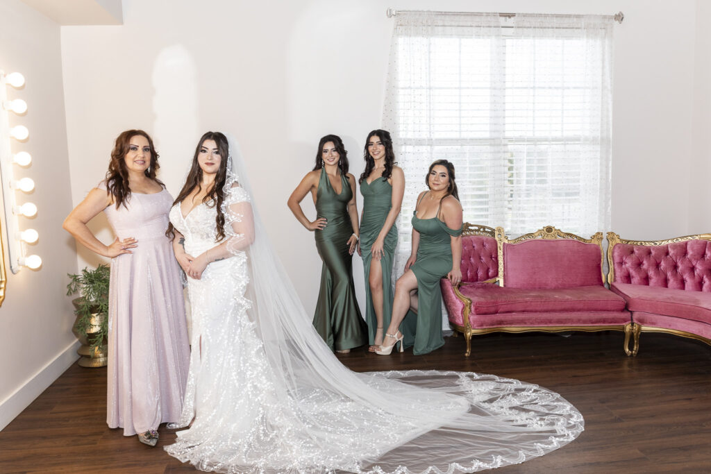 Bride, mom and bridesmaids pose in a glamorous bridal suite, all part of the wedding dress planning team