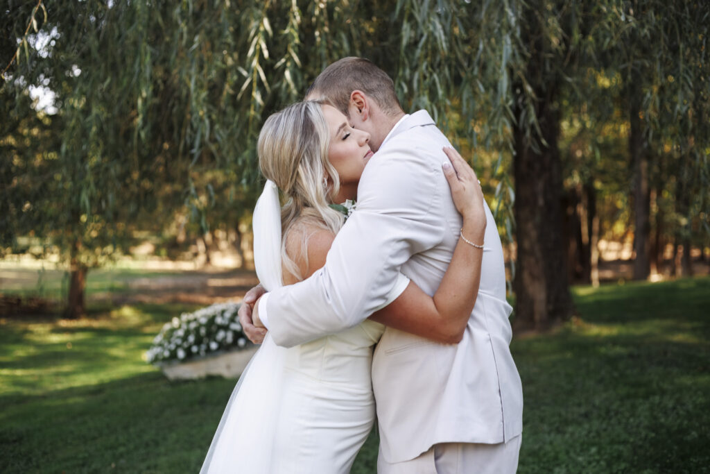 The couple holds each other close under cascading branches, their embrace radiating love and calm during this heartfelt Lehigh Valley wedding moment.
