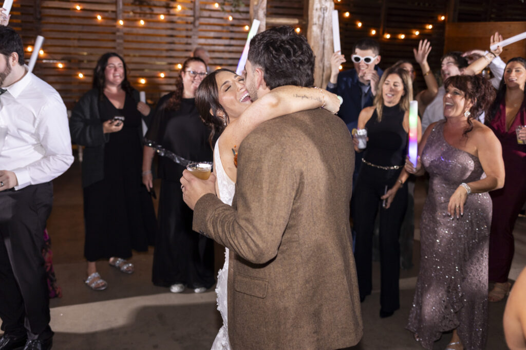 As the reception unfolds at Stoltzfus Homestead, string lights glow above the dance floor while the couple sways together, surrounded by friends, music, and the golden light of their celebration.