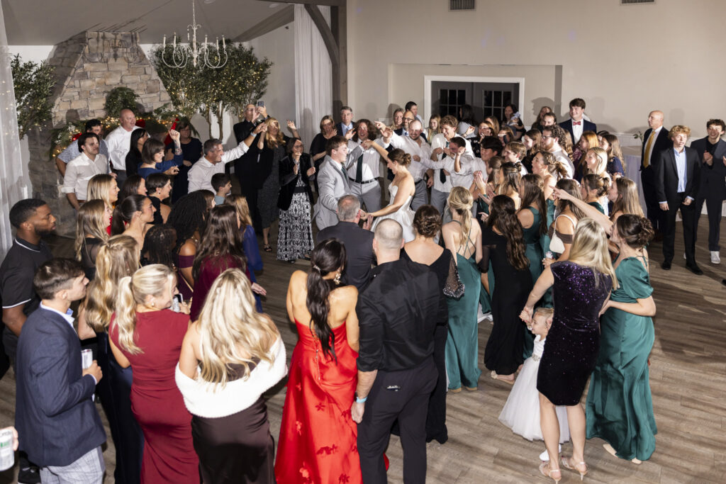 A packed reception dance floor filled with guests surrounding the couple as they dance at the center, hands raised and faces animated, capturing the communal joy and movement that followed their Chattanooga Church Wedding celebration.